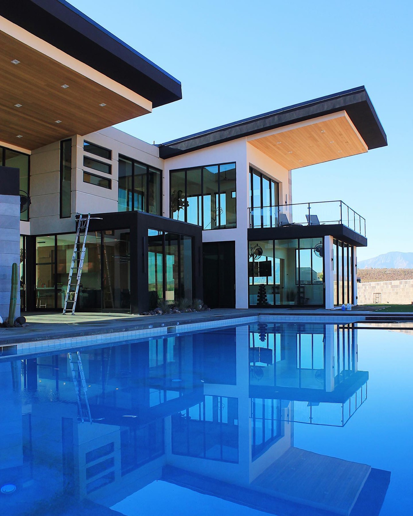 Modern glass home reflected in an infinity pool